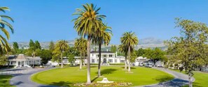 A large, single-story building with a symmetrical facade, surrounded by a well-maintained lawn and palm trees. - 2BR Napa Getaway Side-by-side Condos Golf View (Napa)