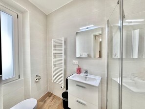 A modern bathroom with a white sink, mirror, and towel rack. - Studio in the old Town of Menton (Menton)