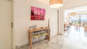 A modern interior with a console table, a painting, and a view to the outside. - Menton Garavan 2BR by the sea Parking (Menton)