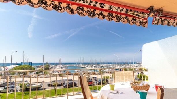 A balcony with a view of a marina and parked cars. - Menton Garavan 2BR by the sea Parking (Menton)