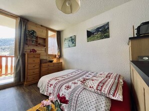1 dormitorio y tabla de planchar con plancha