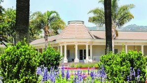 A building with a central dome, surrounded by lush greenery and flowering plants. - 2BR Napa Getaway Side-by-side Condos Golf View (Napa)