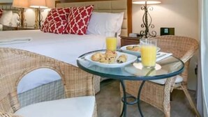 A hotel room with a bed, a dining table with breakfast, wicker chairs, and a mirror. - 2BR Napa Getaway Side-by-side Condos Golf View (Napa)