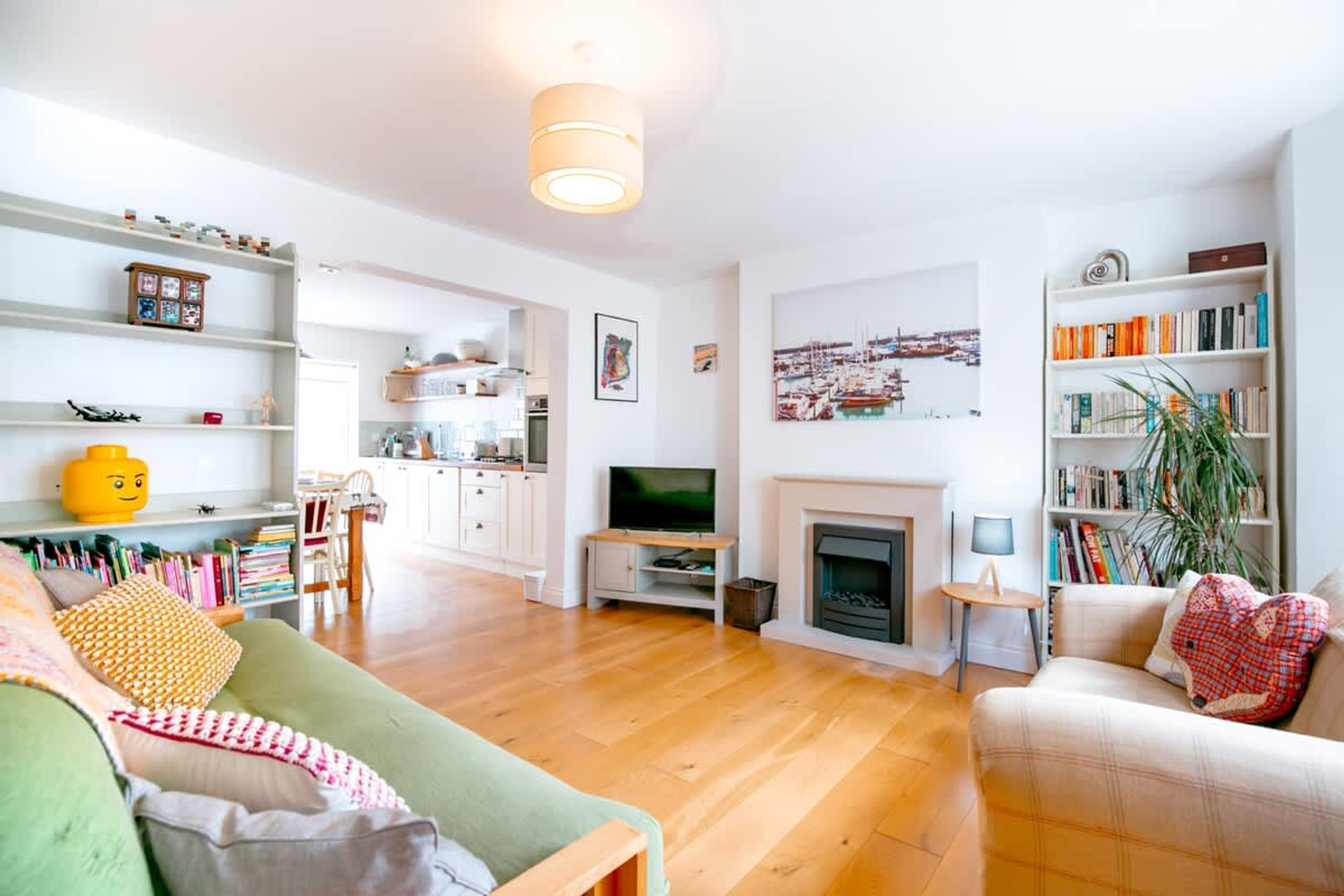 A modern living room with a fireplace, a television, and a bookshelf.