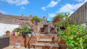 A patio with outdoor furniture, a blue umbrella, and potted plants. - Perfect Booking Near Ramsgate Station And Beach (Ramsgate)