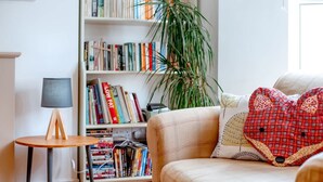 A cozy living room with a sofa, a bookshelf, a lamp, and a plant. - Perfect Booking Near Ramsgate Station And Beach (Ramsgate)