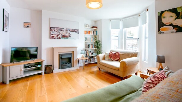 A living room with a fireplace, television, bookshelf, and a sofa. - Perfect Booking Near Ramsgate Station And Beach (Ramsgate)
