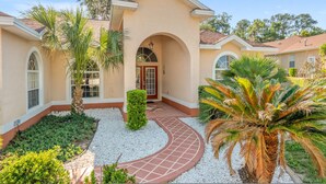 A two-story house with a curved driveway, palm trees, and a well-maintained garden. - Villa Pearl 4-bedroom Poolhome Close To Ocala (Inverness)