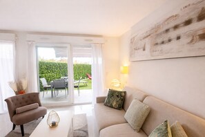 A modern living room with a sofa, armchair, and a dining area with a table and chairs. - Elegant Retreat Near Monaco Private Terrace (Beausoleil)