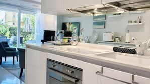 A modern kitchen with a large island, stainless steel appliances, and a view of the outdoors. - Elegant Retreat Near Monaco Private Terrace (Beausoleil)