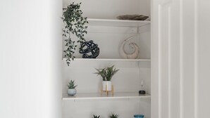 A white shelf with various potted plants and decorative items. - Big Family Home Free Parking Fast Wifi Garden (Kingston Upon Thames)