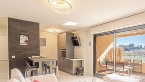Un apartamento moderno con cocina, comedor y balcón con vistas a la ciudad.