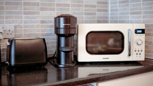 Une cuisine équipée d’un grille-pain, d’une machine à café et d’un four à micro-ondes.