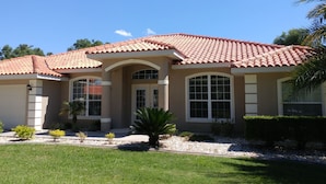 A two-story house with a red-tiled roof, large windows, and a well-maintained lawn. - Villa Corthouts Luxury Home Close to Bike Trail (Inverness)