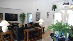 A living room with a sofa, coffee table, TV, and decorative lamps. - Villa Corthouts Luxury Home Close to Bike Trail (Inverness)