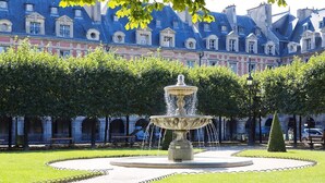 Ein Brunnen in einem Innenhof, im Hintergrund ein Gebäude.