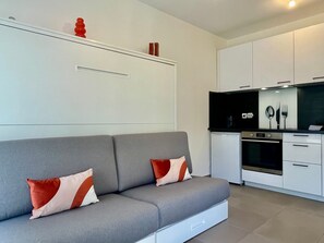 A modern kitchen with white cabinets, a built-in oven, and a black microwave. - Charming Studio With Parking Near Monaco (Beausoleil)