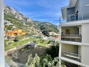 Ein Wohngebiet mit Bergblick, ein gelbes Haus und ein modernes Gebäude mit Balkonen.