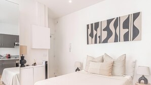 A modern bedroom with a bed, bedside tables, a desk, and a wardrobe. - Nice Studio Close to Monaco (Beausoleil)