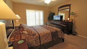 A hotel room with a bed, a television, a ceiling fan, a dresser, and a window with blinds. - Wedding Venue View Apartment (Inverness)