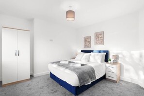 A bedroom with a bed, bedside table, wardrobe, and two wall art pieces. - Perfect Booking 5 min Drive to Blyth Beach (Blyth)