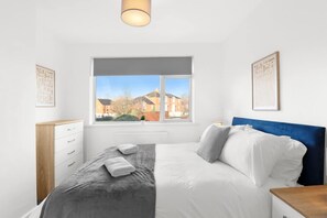 A bedroom with a bed, a window, a dresser, and a nightstand. - Perfect Booking 5 min Drive to Blyth Beach (Blyth)