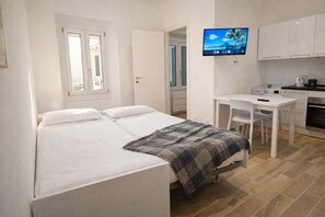 A bedroom with a bed, a desk, a chair, and a television. - Cozy Studio in the Heart of Menton s old Town (Menton)