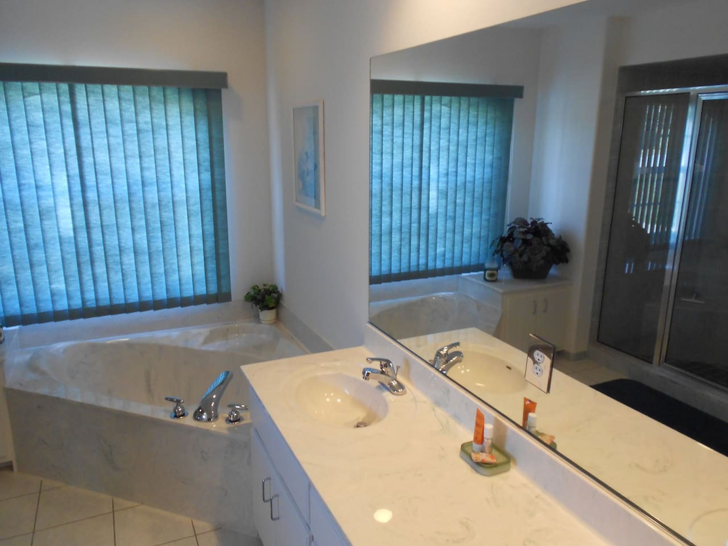 Une salle de bain avec une grande baignoire, deux lavabos et une douche.