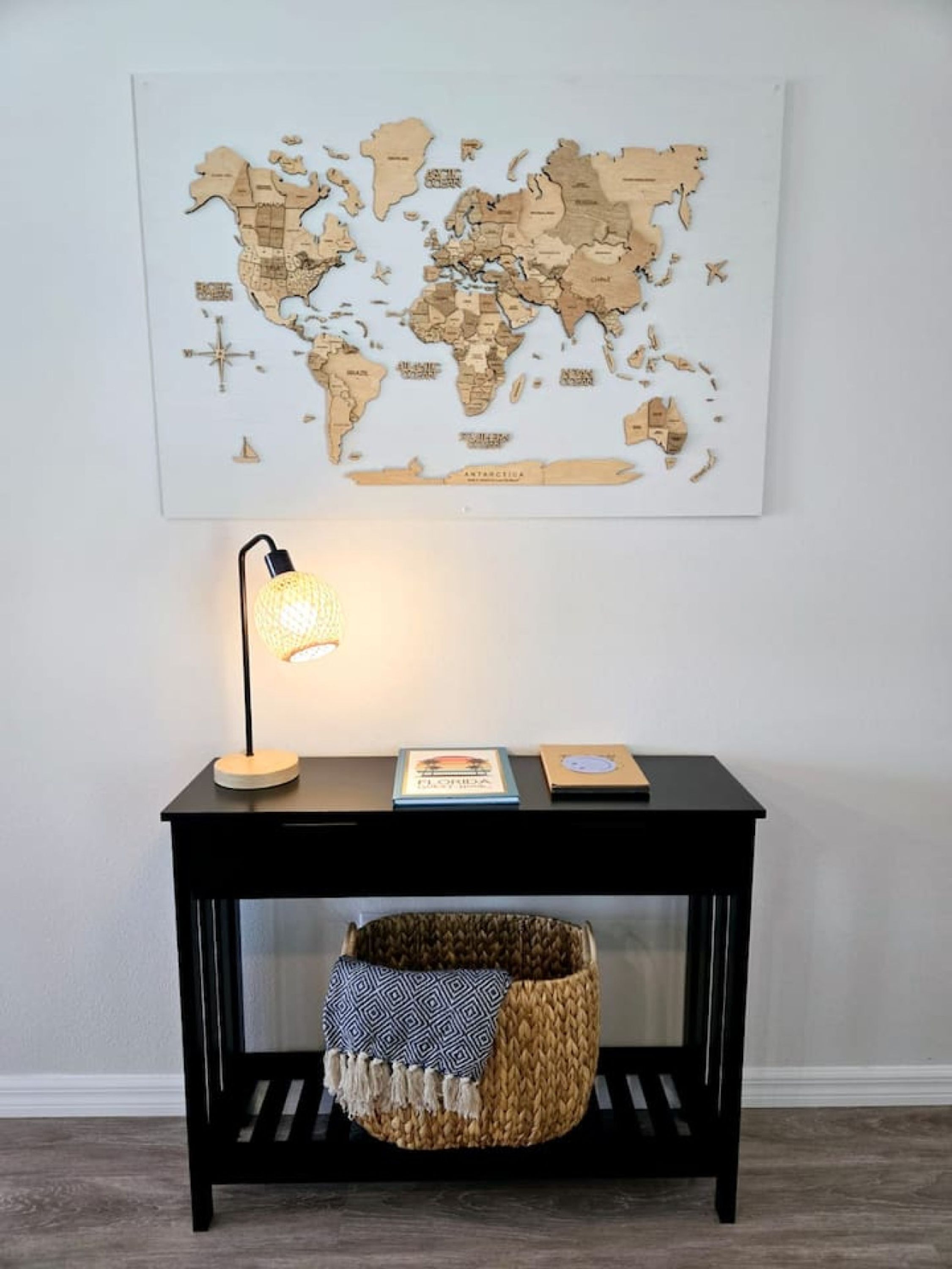 Un mapa mundial en la pared, un escritorio con una lámpara y una cesta tejida.