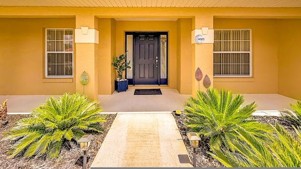 A building with a yellow facade, a black door, and a number '4325' on the wall. - Villa Havelaar Family Friendly and Awesome Pool (Inverness)