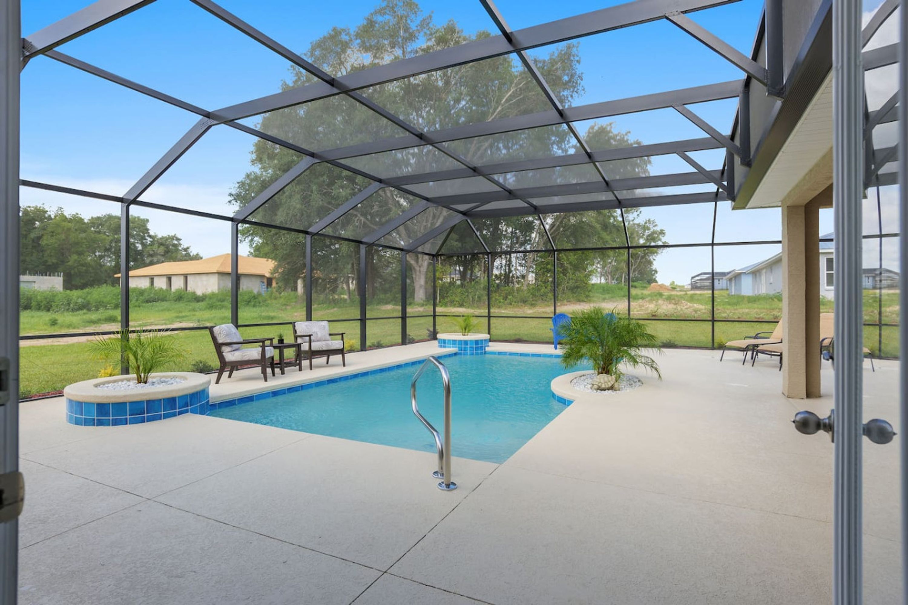 A covered outdoor swimming pool with lounge chairs and a hot tub.
