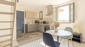 Une cuisine moderne avec un coin repas, un escalier et une vue par la fenêtre.