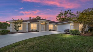 A residential house with a driveway, front lawn, and a garage. - Villa S G Spacious 5 Bedroom Family Vacation Home (Inverness)