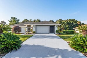 A single-story house with a garage, surrounded by well-maintained lawns and tropical plants. - Villa Prins Two Spacious Primary Bedrooms With Ensuites (Inverness)