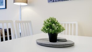 A white dining table with a potted plant, white chairs, and a lamp. - High Wycombe Home Free Parking Free Wifi Garden (High Wycombe)