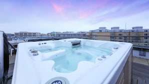Una terraza con jacuzzi y vistas de la ciudad.