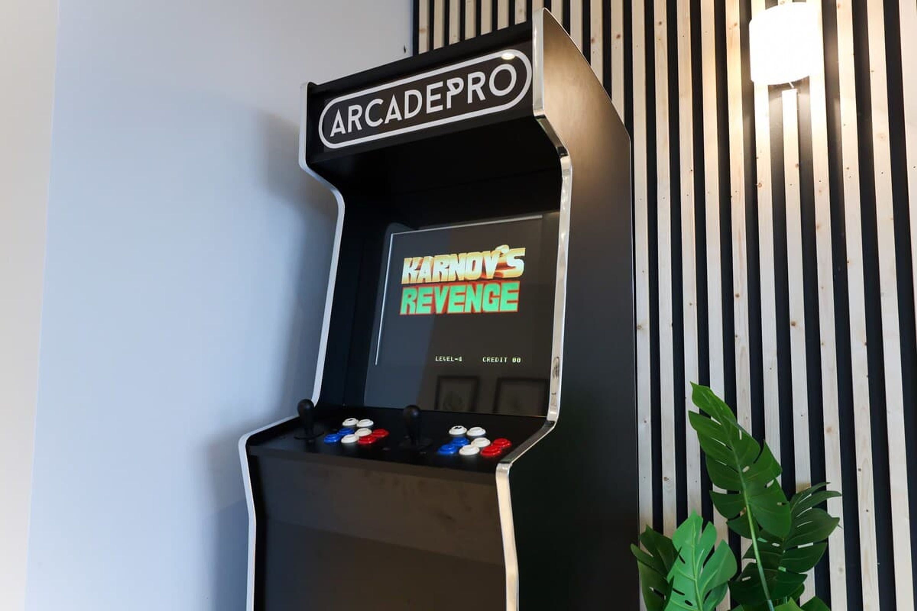 An arcade machine labeled 'ArcadePro' with 'Karnov's Revenge' displayed on the screen.