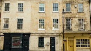 A row of historic buildings with multiple windows and doors, including a black door labeled 'No. 5' and a yellow door with 'FOUR' above it. - Stunning Bath Home Sleeps 12 Ideal for Hen Stags (Bath)