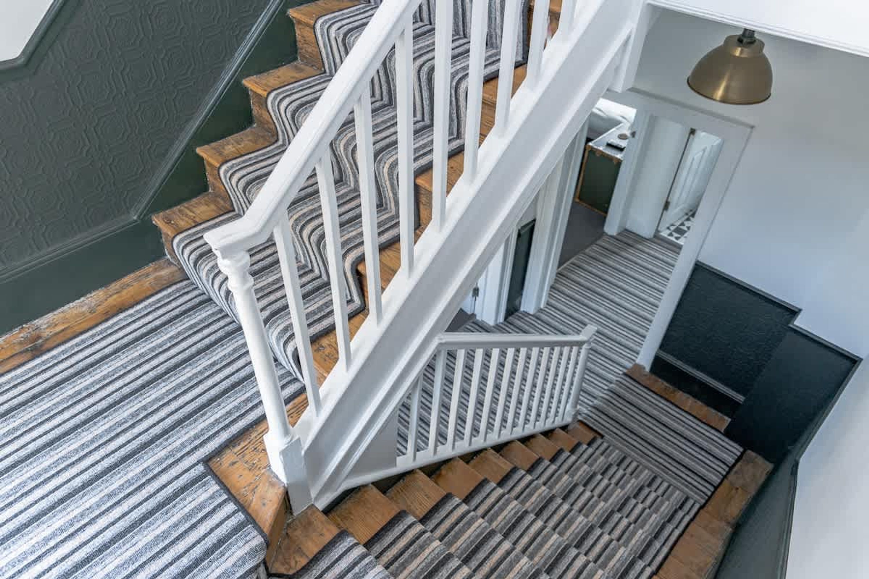 Una escalera con barandillas blancas y un suelo estampado.