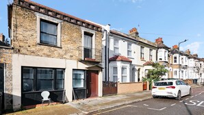 A row of terraced houses with a white car parked on the street. - Perfect Booking 3 Bed Home In Kensal Green (London)