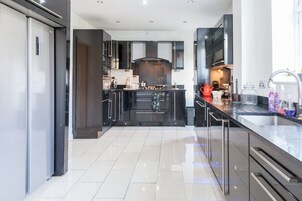 A modern kitchen with dark cabinetry, a central island, and a large window.