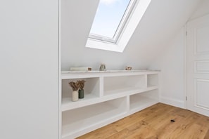A room with a skylight, white walls, and wooden flooring. - Southampton Getaway Huge Home Garden Sleeps 10 (Southampton)