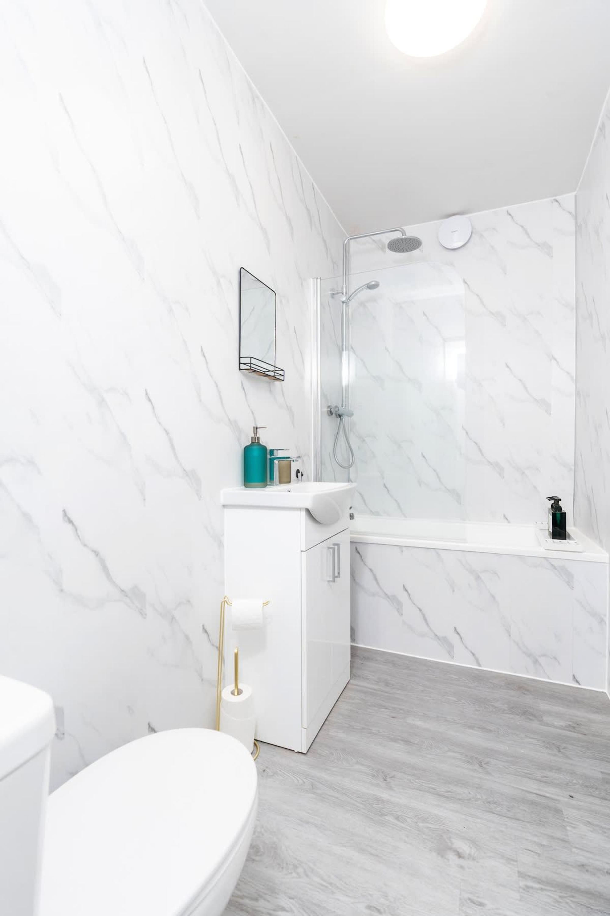 Een moderne badkamer met toilet, wastafel en douche.