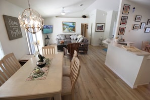 A modern living space with a dining area, a kitchen island, and a seating area. - Villa Willow Wood 3-bedroom Home Private Pool (Inverness)