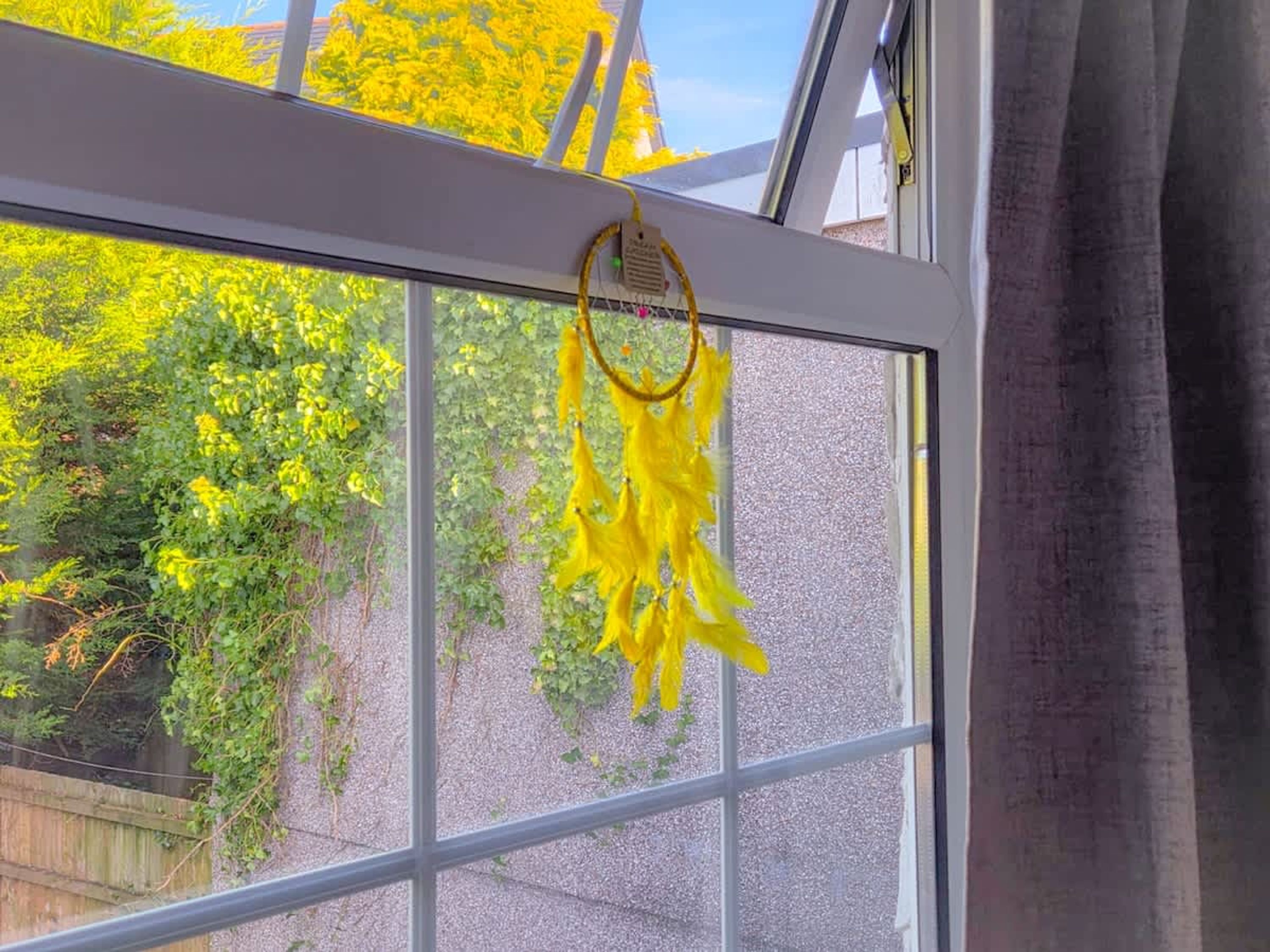 Ein Fenster mit Blick auf Grün und einem gelben Dekoelement.