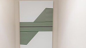 Eine Treppe mit modernem Design, eine weiße Tür unten und ein Wandbild darüber.