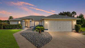 Una casa a due piani con garage, vialetto e giardino anteriore curato.