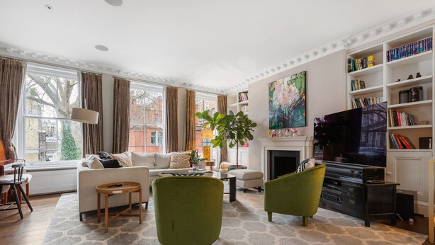 Una sala de estar con chimenea, televisor y estantería.