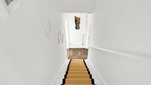 Eine Treppe mit hölzernem Geländer und einer weißen Wand.