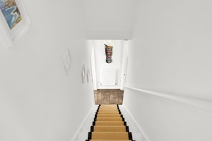 A staircase with a wooden handrail and a white wall. - Modern 2BR House Near DLR | Isle of Dogs (London)